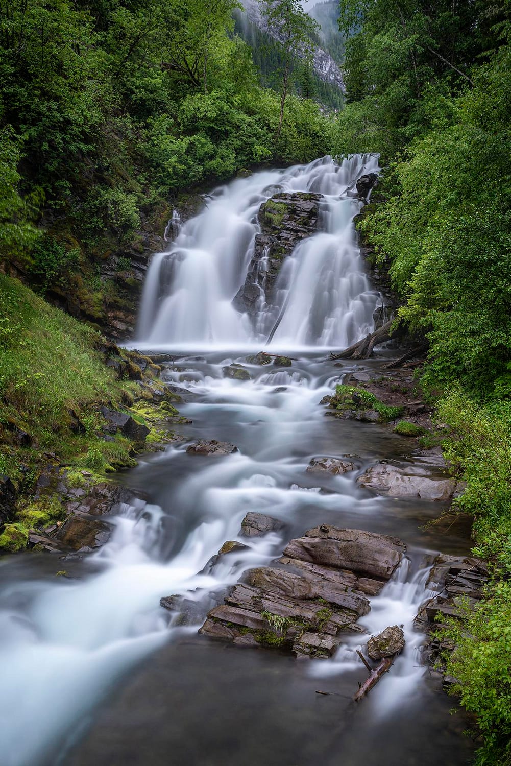 a large waterfall surrounded by lush green forest