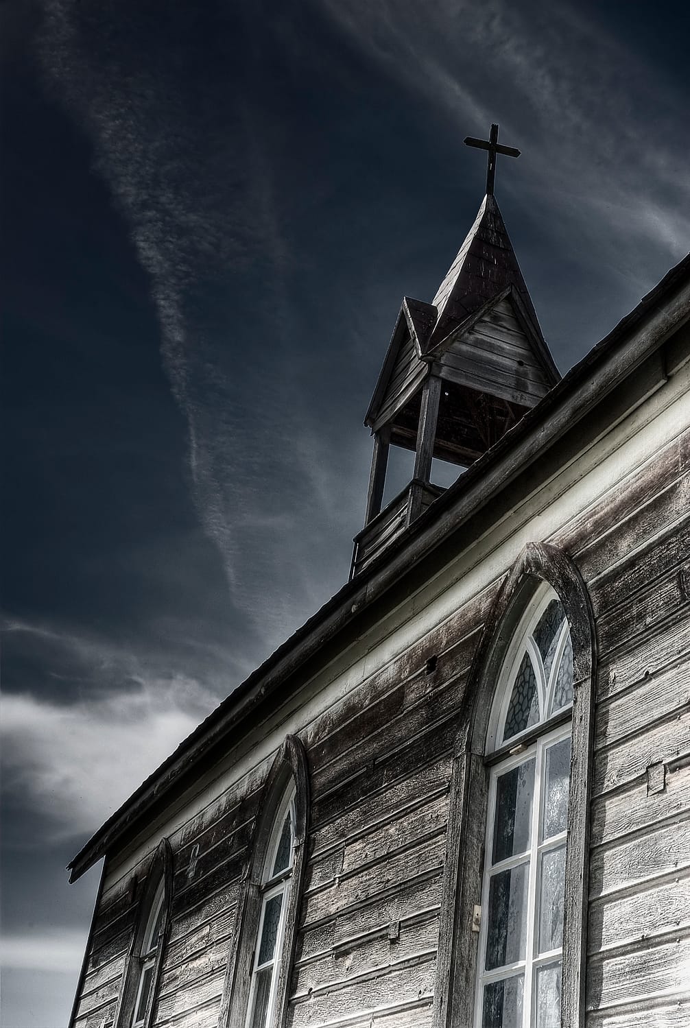 an old prairie church with a cross on the top