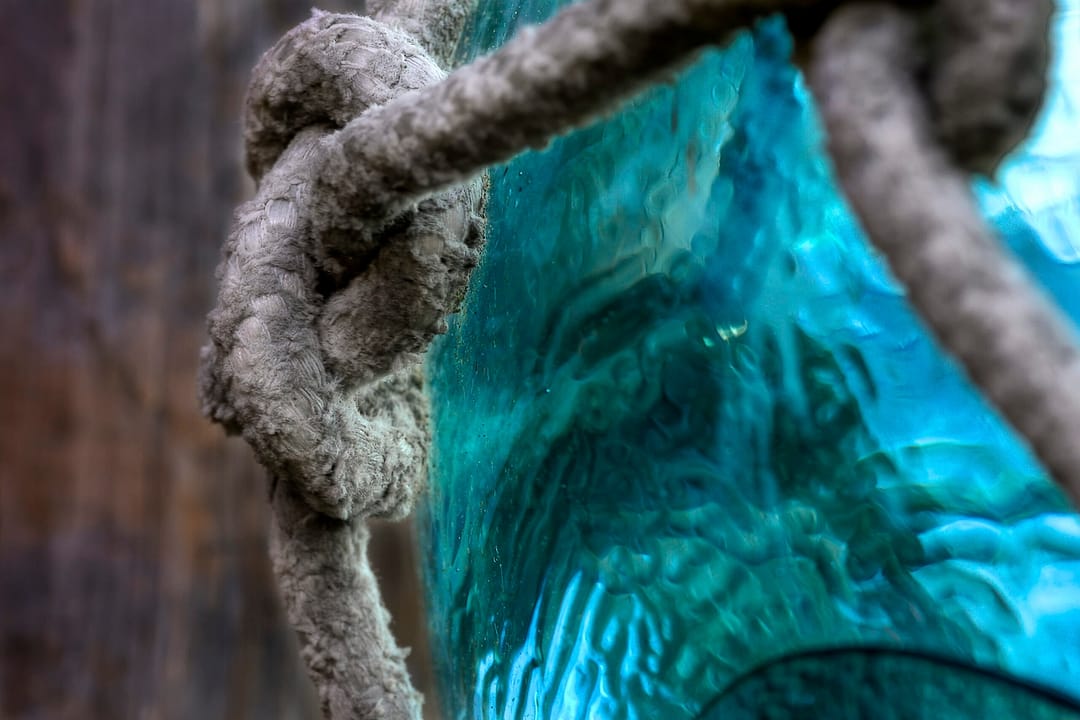 a close up of a knotted rope around a vintage glass float
