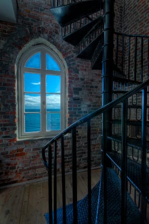 a window in a lighthouse looking over the pacific ocean