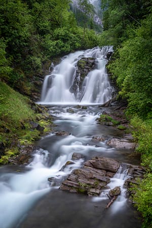 a large waterfall surrounded by lush green forest