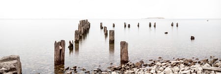 a abandoned dock on a misty lake with rocks