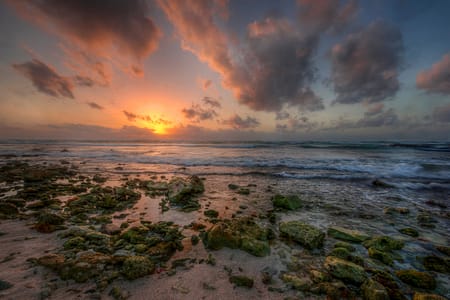 sunrise over a rocky beach and ocean in the Mayan Riviera