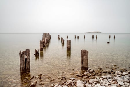 an abandoned dock in a lake with rocks
