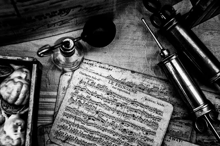 a still life of music sheets and antiques