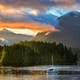 sunset on the pacific coast with a boat and mountains
