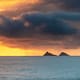 a sunrise over small Hawaiian islands in the ocean
