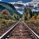 A railway in fall leading towards a mountain