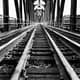 a black and white image of a train bridge