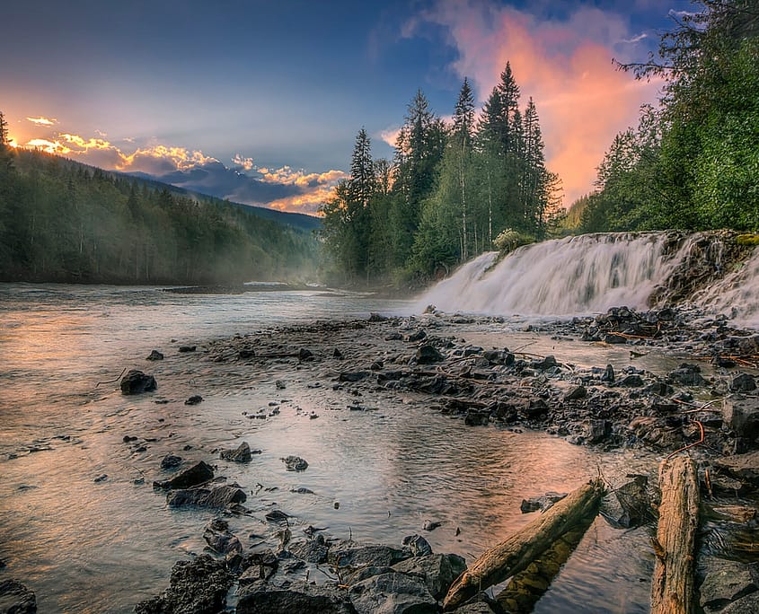 Sunset beaming over a river waterfall