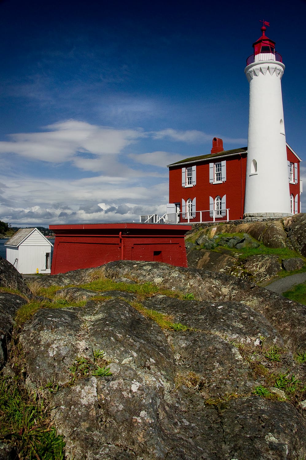 a large red lighthouse on a rocky point